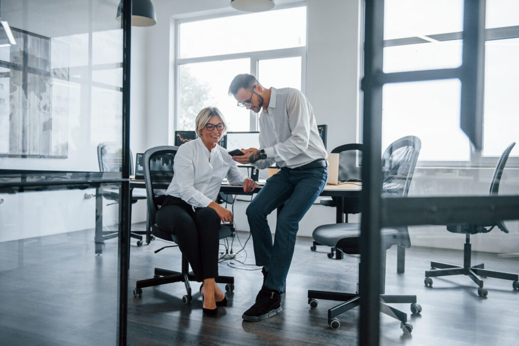 Two stockbrokers in formal clothes works in the office with financial market